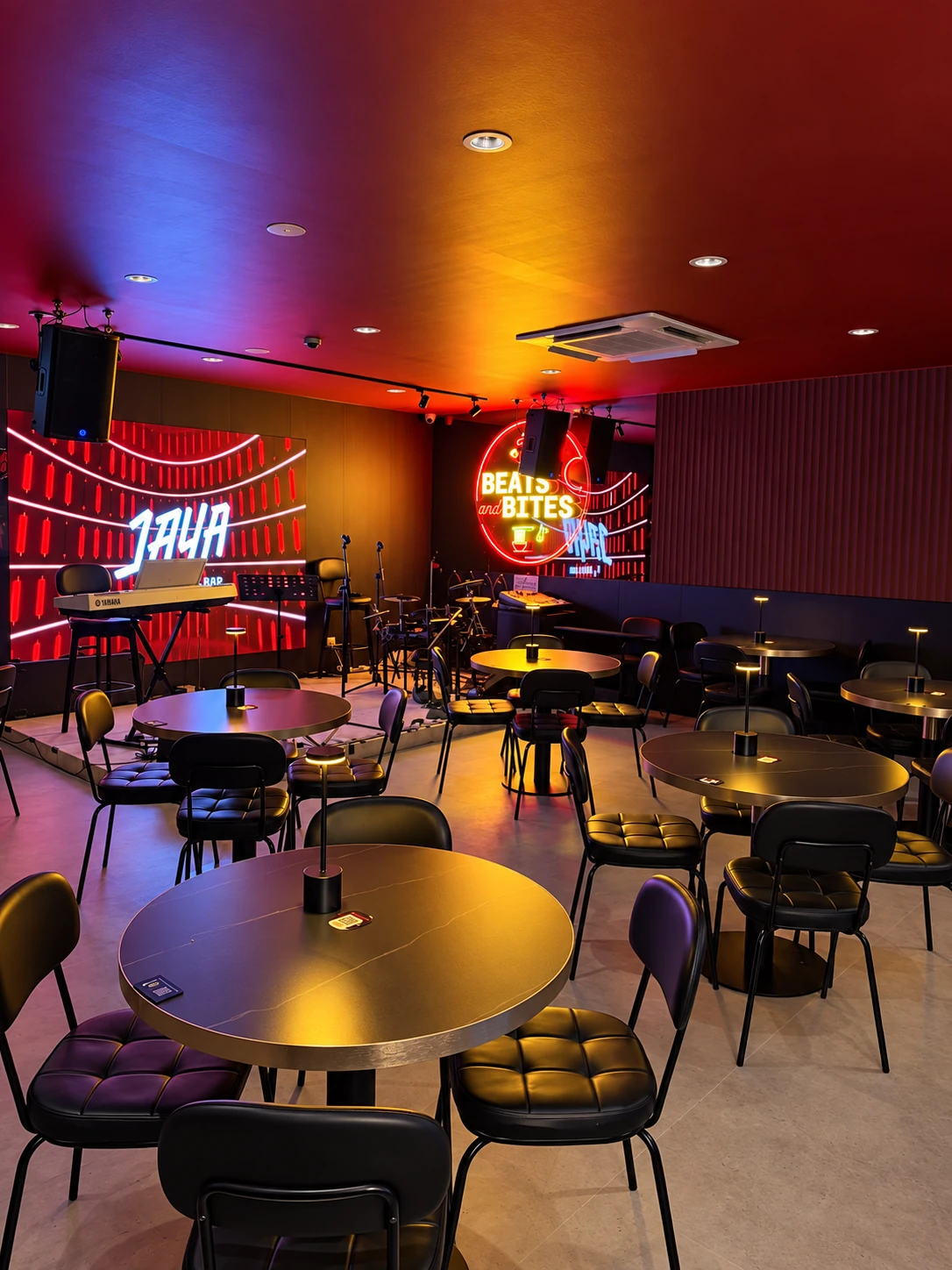 The JAYA stage projection, live music equipment and tables in the main room