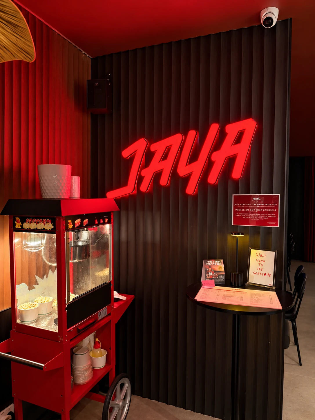 Jaya’s red illuminated entrance sign beside the popcorn cart