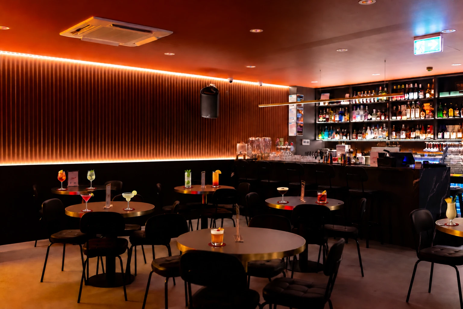 Jaya’s warm-lit dining room, styled with classic cocktails on coasters at the tables